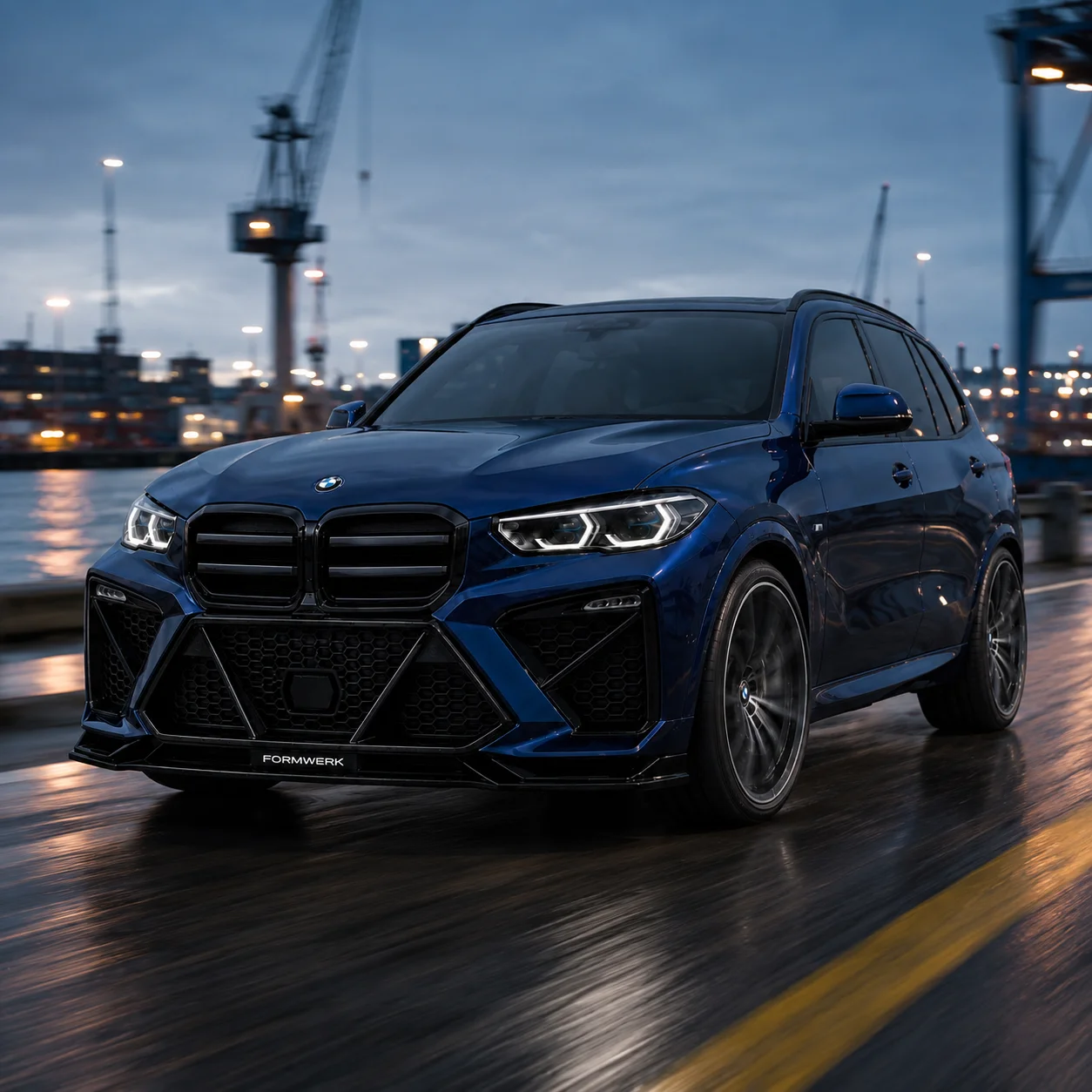 A blue X5 with the Bulldog front, driving at the harbour.