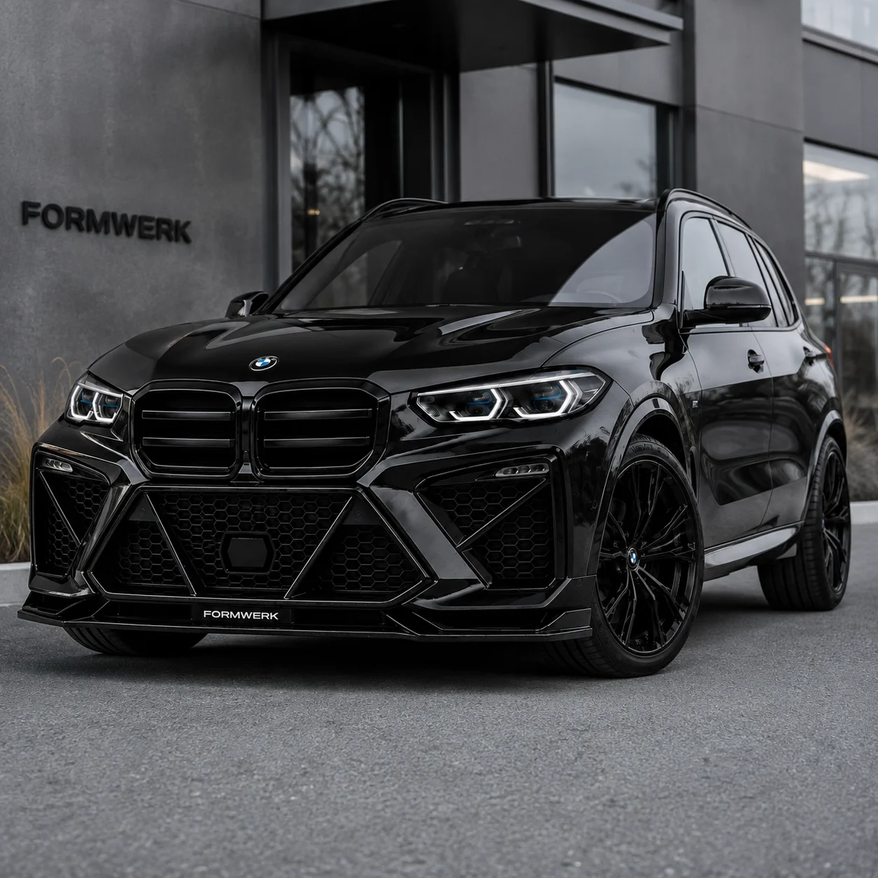 a black X5 with the Bulldog front, three quarters, wet ground.